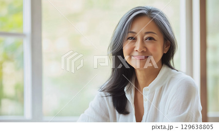 Mature woman with glowing skin and natural makeup in soft warm light for anti-aging beauty stock 129638805