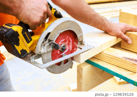 Circular saw cutting wood at construction site on craftsmanship careful precision 129639120