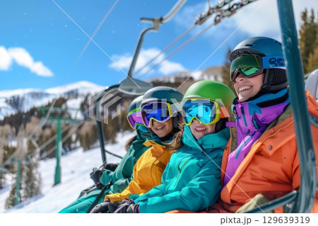 Kids in colorful jackets riding a chairlift 129639319