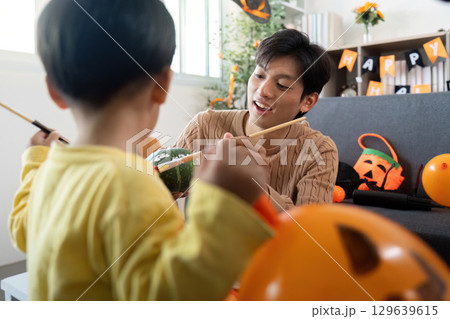 Halloween Crafts. Father and son painting pumpkins together. Halloween Crafts. Father and son painting pumpkins together. 129639615
