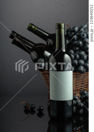 Red wine and blue grapes on a black reflective background. Red wine and blue grapes on a black reflective background. 129640052