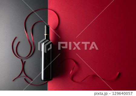 Bottle of red wine with red satin ribbons. 129640057