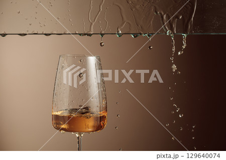White wine flows down into a glass. 129640074