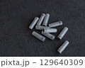 Collection of Gray Colored Plastic Tubes on a Black Surface: Examining Everyday Objects with Unique Shapes and Textures 129640309