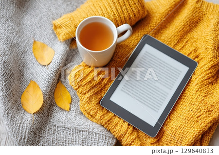 Cozy journaling moment with warm tea and autumn leaves on a soft textured blanket 129640813