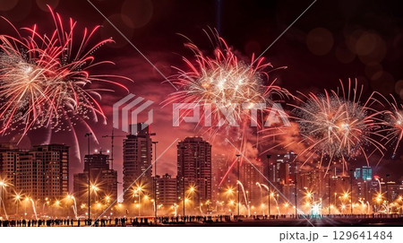 At night, a dazzling fireworks display lights up the city skyline At night, a dazzling fireworks display lights up the city skyline 129641484