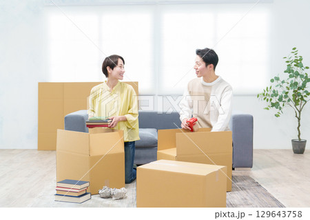 引っ越しの準備をする若い夫婦 129643758