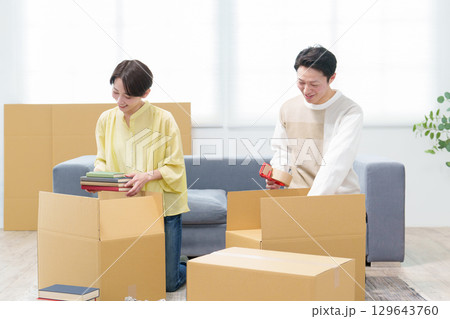 引っ越しの準備をする若い夫婦 129643760