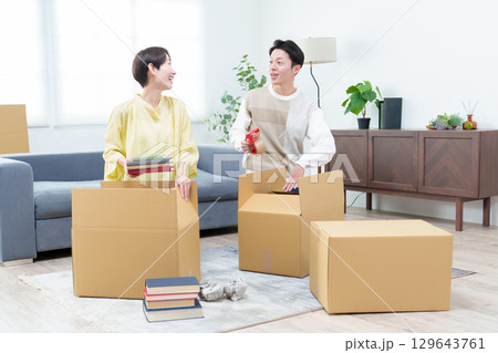 引っ越しの準備をする若い夫婦 129643761