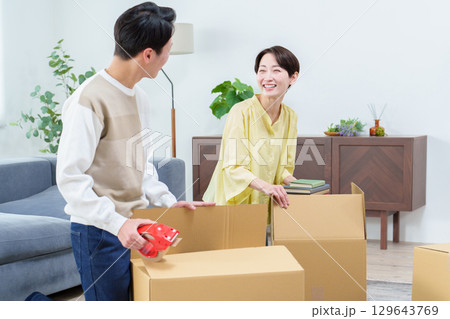 引っ越しの準備をする若い夫婦 129643769