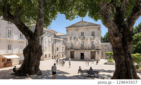 Sunlit european square with people relaxing and strolling Sunlit european square with people relaxing and strolling 129643917