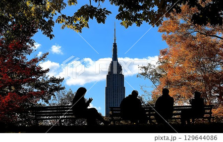 Autumnal Silhouette of People on Bench with Empire State Buildin 129644086