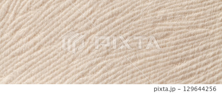Light beige background, soft fluffy textile material macro. Texture of cream plush fabric backdrop. Wavy pattern 129644256