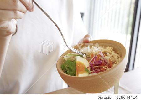 彩り豊かなサラダを食べる女性 129644414