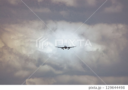 福岡空港　雲の中を飛ぶ飛行機 129644498