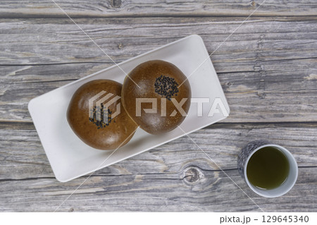 俯瞰から観たテーブルにある和菓子のあんぱんと日本茶 129645340
