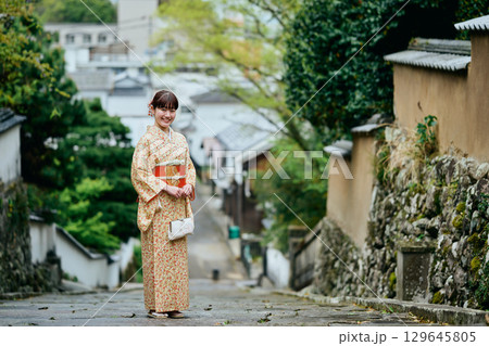 石畳の坂道を歩く着物姿の女性 石畳の坂道を歩く着物姿の女性 129645805