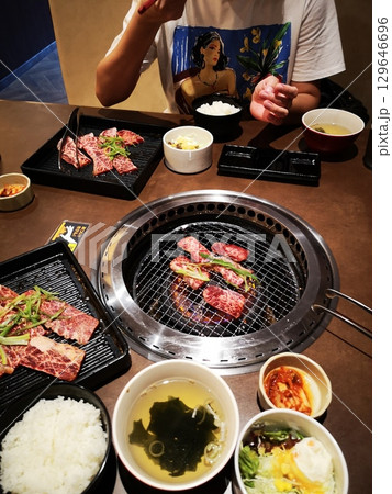 新装開店の焼肉屋で焼肉ランチを食べる中国人女性 新装開店の焼肉屋で焼肉ランチを食べる中国人女性 129646696