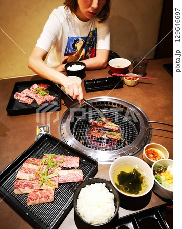 新装開店の焼肉屋で焼肉ランチを食べる中国人女性 新装開店の焼肉屋で焼肉ランチを食べる中国人女性 129646697