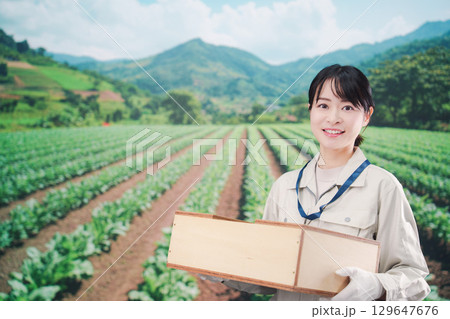 箱を運搬する農家の若い女性 箱を運搬する農家の若い女性 129647676