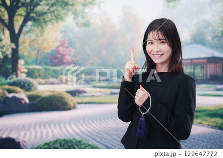 喪服を着て数珠を持って手を合わせる女性 喪服を着て数珠を持って手を合わせる女性 129647772