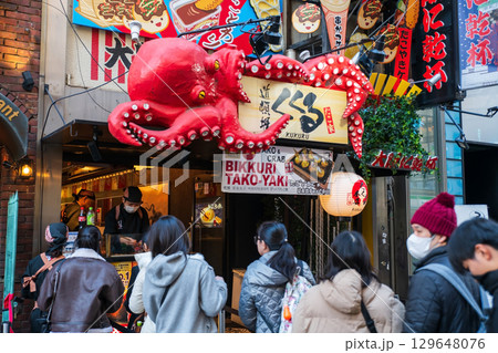 Japanese people at Tako yaki shop with iconic octopus board, Osaka 129648076