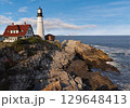 Portland Head Light in late afternoon surrounded by with dramatic waves and cliffs, Maine, USA 129648413