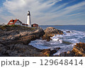Portland Head Light in late afternoon surrounded by with dramatic waves and cliffs, Maine, USA 129648414