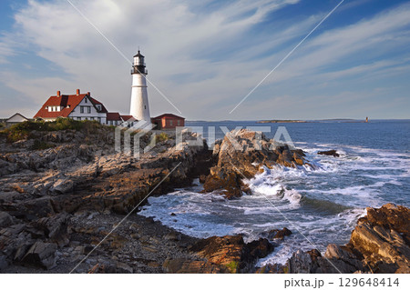 Portland Head Light in late afternoon surrounded by with dramatic waves and cliffs, Maine, USA 129648414