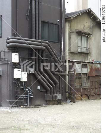 錆びたトタンの家と現代的なビルが隣接する路地裏 錆びたトタンの家と現代的なビルが隣接する路地裏 129649703