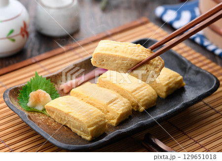 出来立て熱々の出汁巻き卵 和食の定番料理 家庭料理や居酒屋メニューに最適な食卓イメージ 出来立て熱々の出汁巻き卵 和食の定番料理 家庭料理や居酒屋メニューに最適な食卓イメージ 129651018