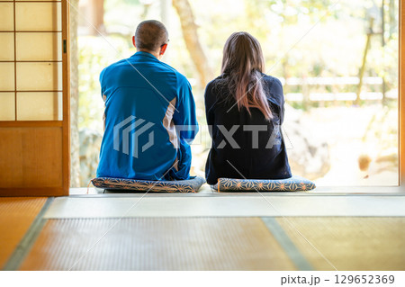 田舎風の家の和室の縁側で語らっている男女 129652369