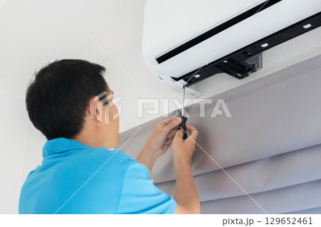 Electrician man repair and maintenance air conditioner 129652461