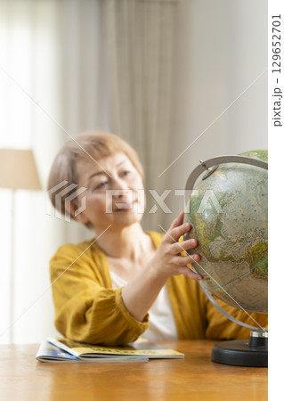 旅行の計画を楽しみにしているシニア女性 129652701