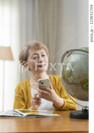 旅行の計画を楽しみにしているシニア女性 129652704