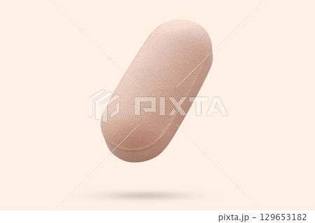 Pink medicine pill tablet float on beige background Pink medicine pill tablet float on beige background 129653182