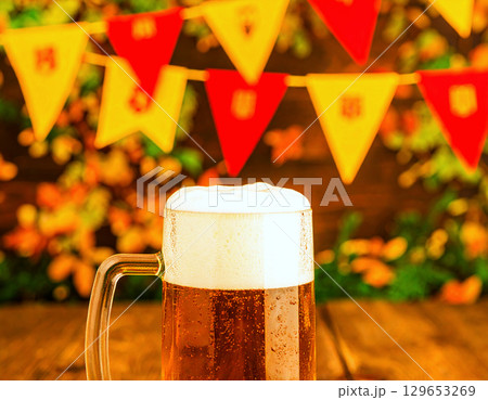 Oktoberfest bunting backdrop with close-up of a frothy, chilled beer stein 129653269