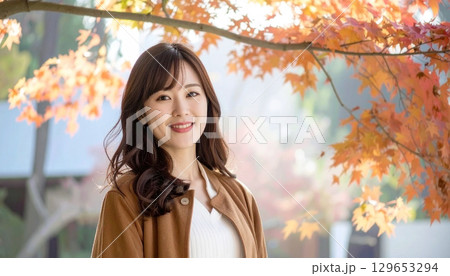 秋の紅葉を背景に立つ日本人女性 秋色コーデ 秋の紅葉を背景に立つ日本人女性 秋色コーデ 129653294