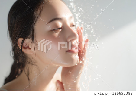 水しぶきを浴びながら素肌をケアする美しい女性、健康的なライフスタイル 129653388