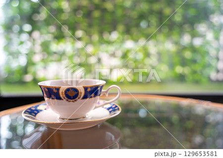 ガラステーブルの上に置かれたコーヒーカップ 129653581