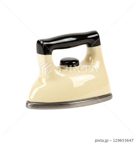 Vintage beige ceramic iron with a black handle and a classic retro design for home decor 129653647