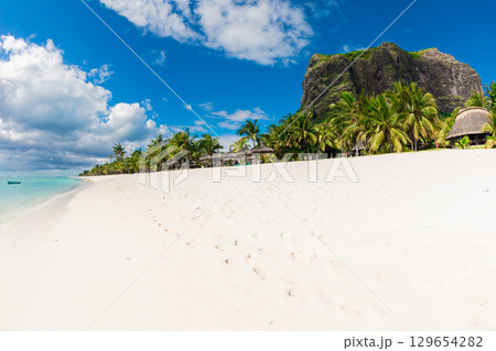 Tropical view of resort on Mauritius. Ocean, white sand beach, palms and blue sky Tropical view of resort on Mauritius. Ocean, white sand beach, palms and blue sky 129654282