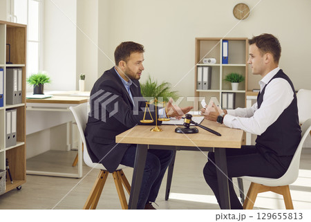Man lawyer working on his workplace in office having discussion during consultation with a client Man lawyer working on his workplace in office having discussion during consultation with a client 129655813