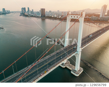 Aerial view of Han River suspension bridge with Danang skyline at sunset, Drone panorama of modern Danang bridge crossing Han River with cityscape background Aerial view of Han River suspension bridge with Danang skyline at sunset, Drone panorama of modern Danang bridge crossing Han River with cityscape background 129656799