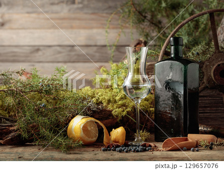 Gin in a small glass and an antique bottle of dark glass. 129657076