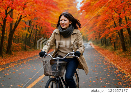 紅葉の中、サイクリングを楽しむ女性 129657177