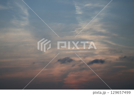 茜色の雲と青空の夕空の風景 129657499