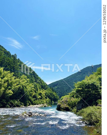 穏やかな青空と山間を流れる渓流の風景 穏やかな青空と山間を流れる渓流の風景 129658002