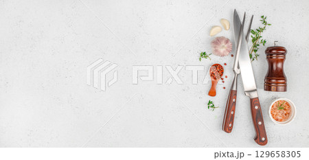 Kitchen utensils and seasonings arranged on a light countertop for culinary preparation. top view. copy space 129658305