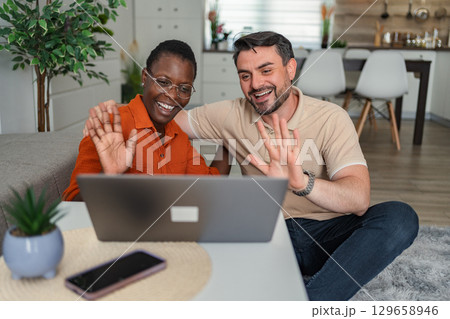 Couple Video Calling and Waving at Someone from Home 129658946